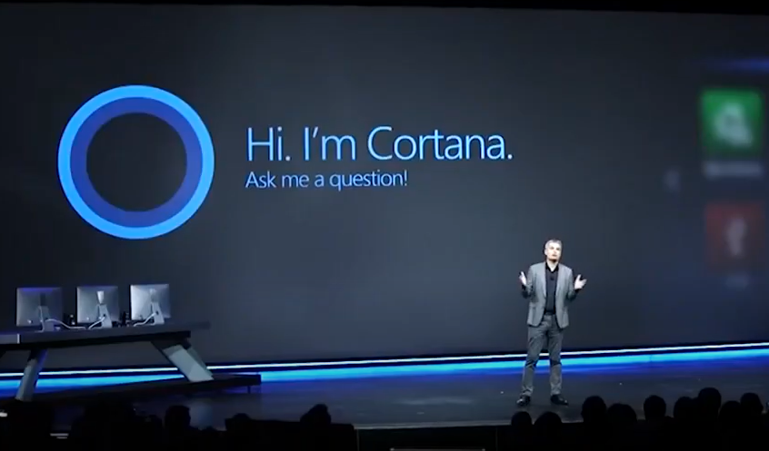 A man presenting in front of a big screen